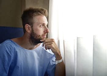 在医院窗口旁边的男性患者